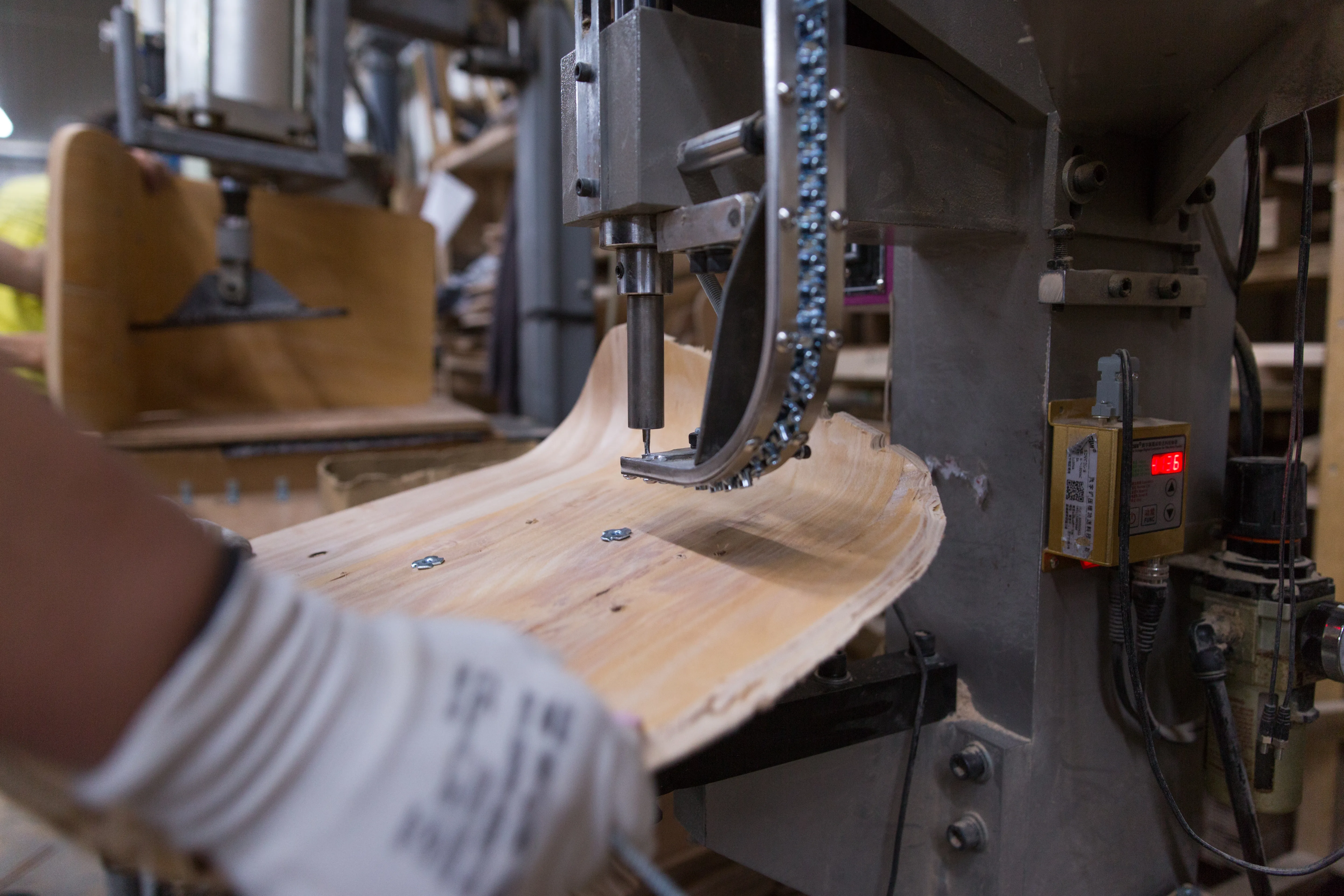 A bent-laminated wood component being shaped on a bandsaw.