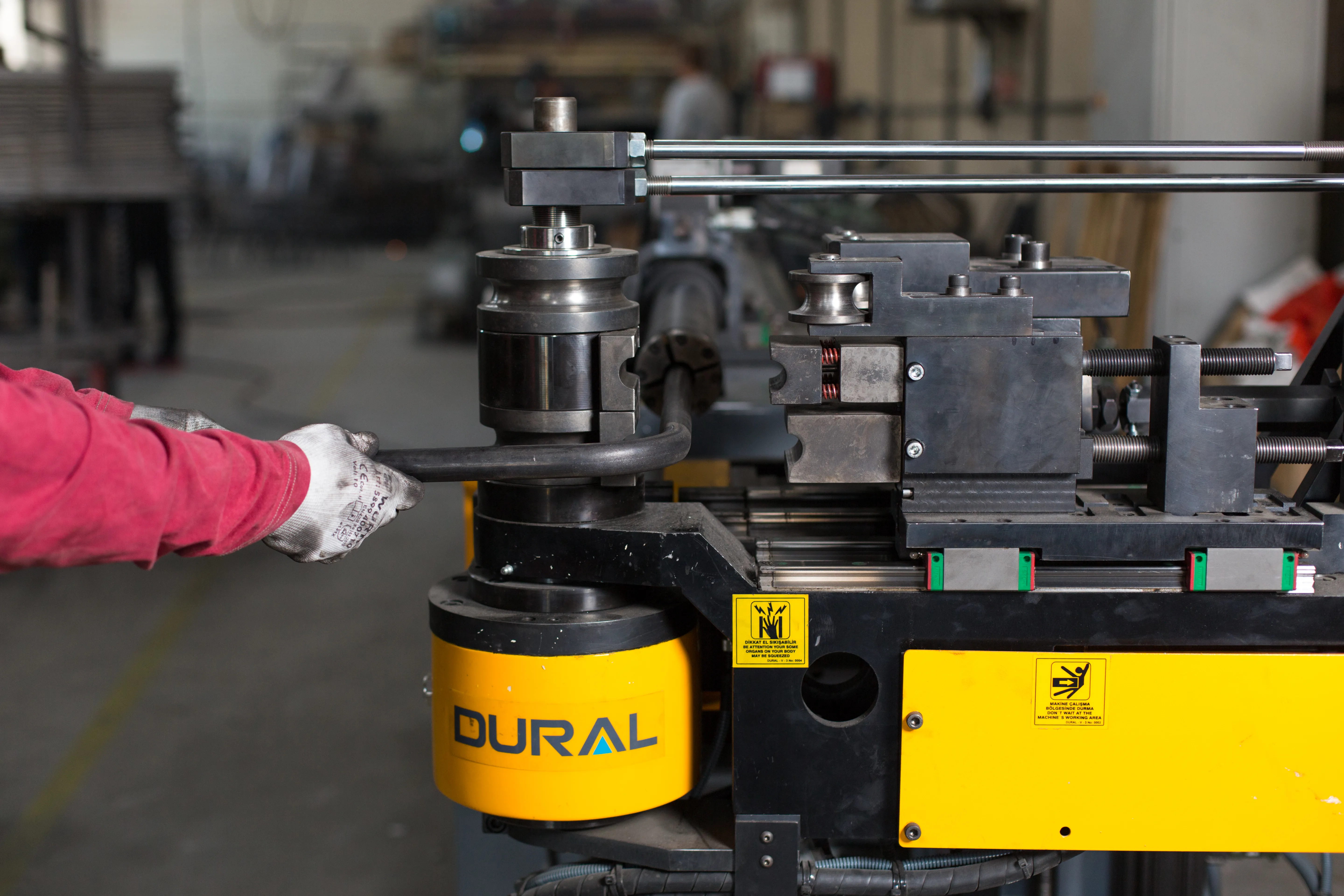 A pipe bender forming the metal frame for an upholstered chair.
