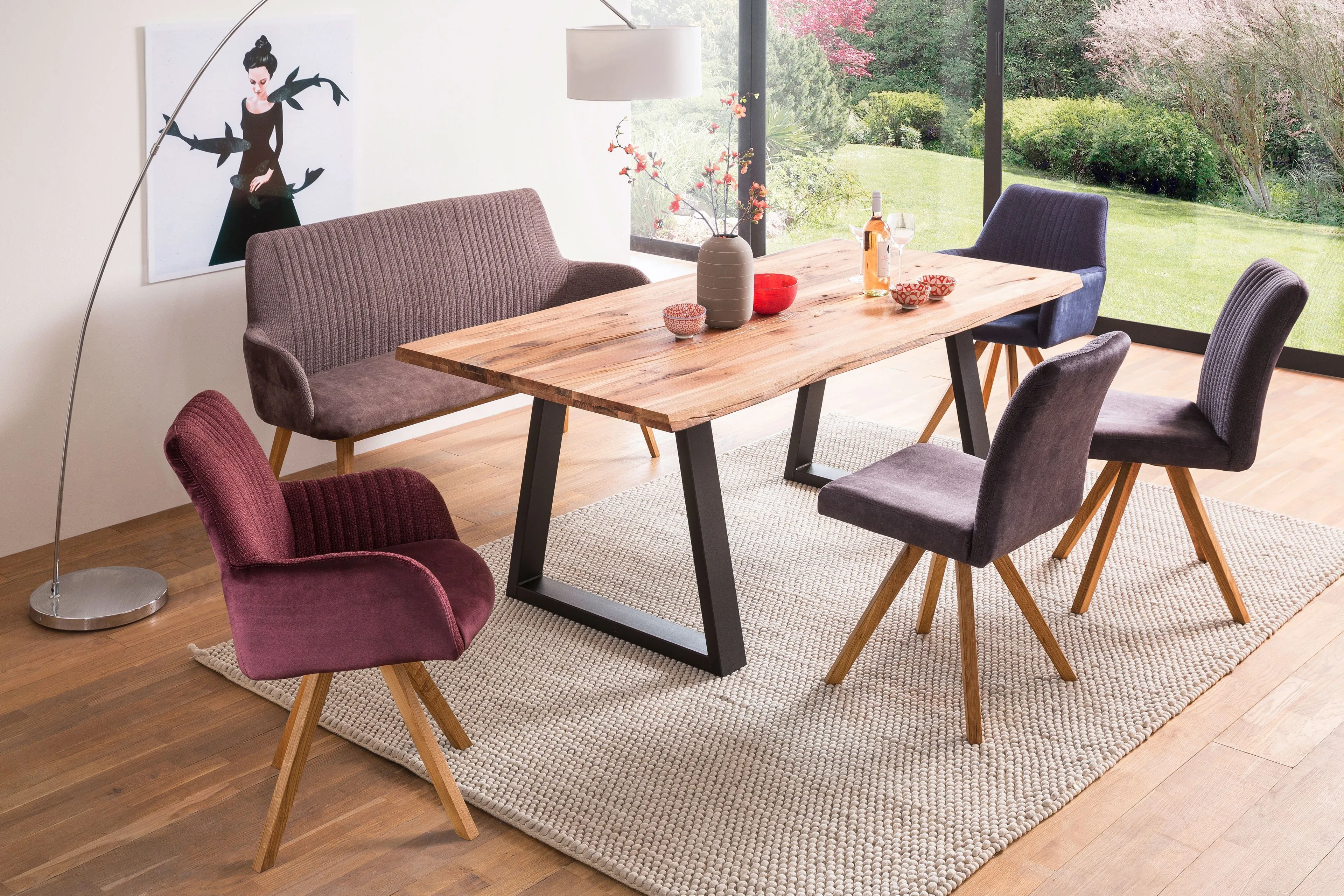 A residential dining setting featuring fully upholstered chairs in varied tones.