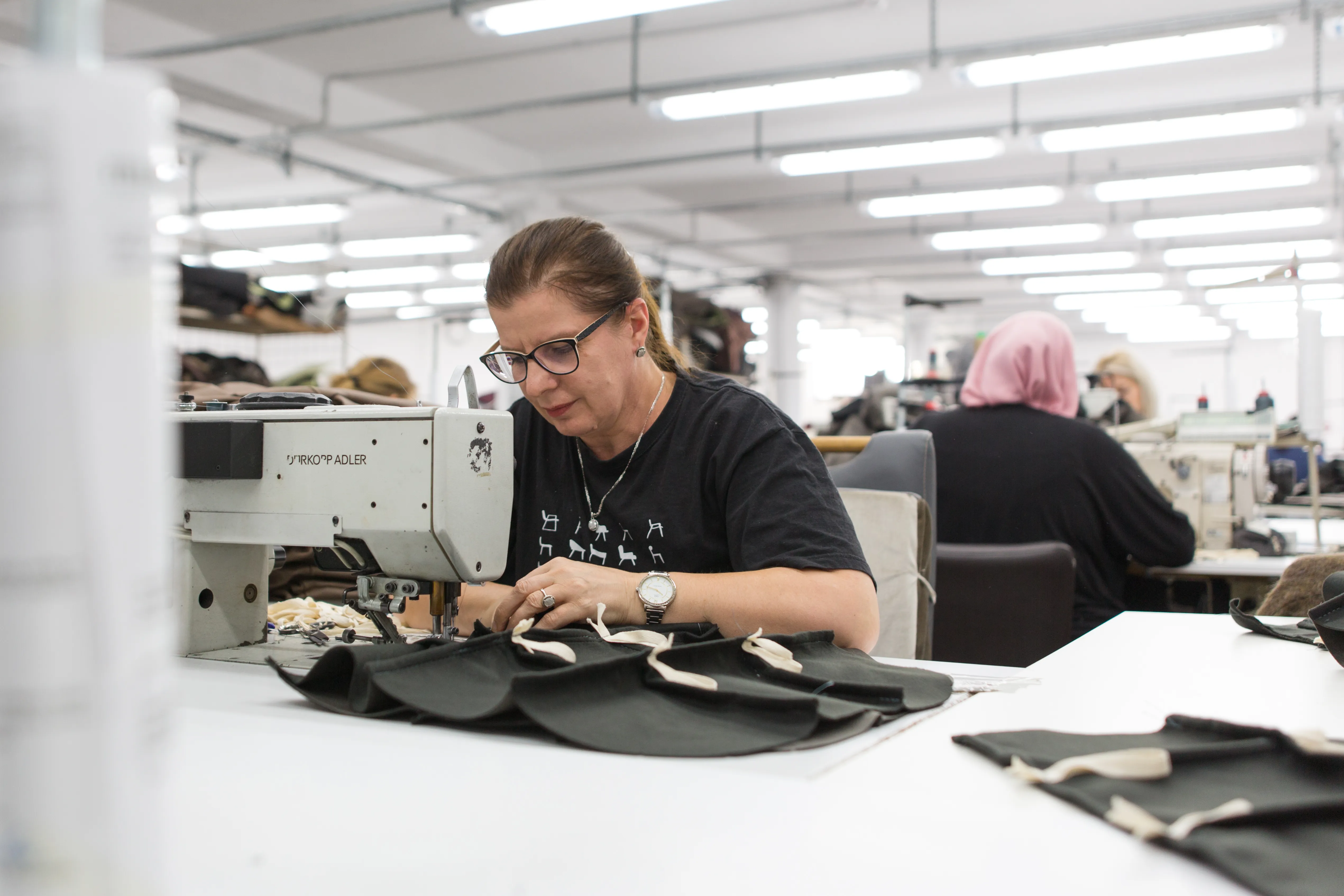 An operator at a Dürkopp Adler industrial sewing machine.